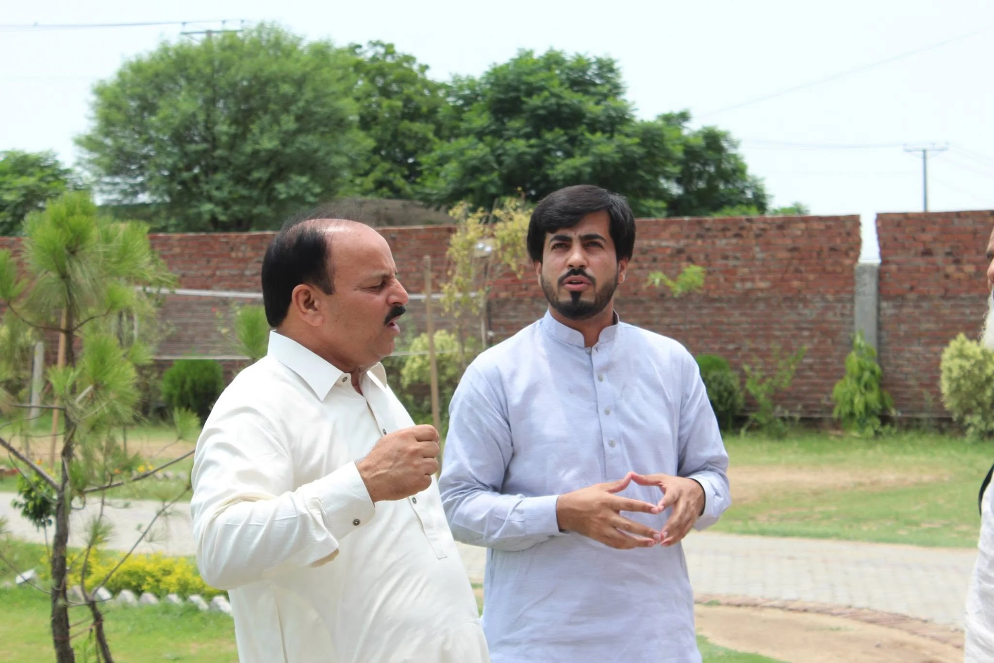 Ch. Muhammad Aslam Sikho and Faruukh Nadeem discussing the school campus and environment during the BISE Gujranwala visit in 2014.